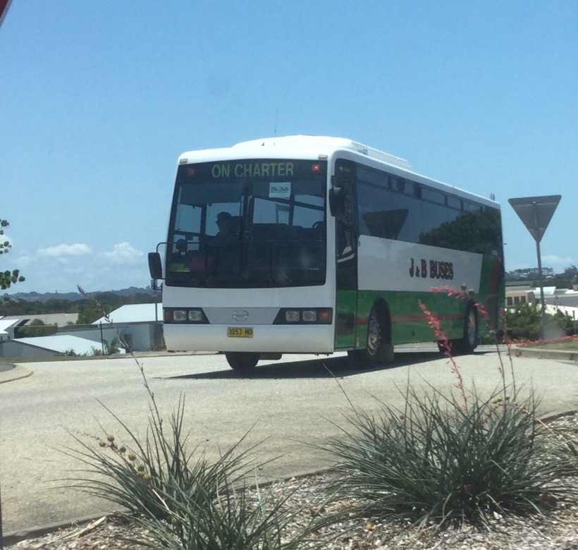 Driving through Casuarina, a J &amp; B Buses Hino with registration 3053MO drives past on Charter